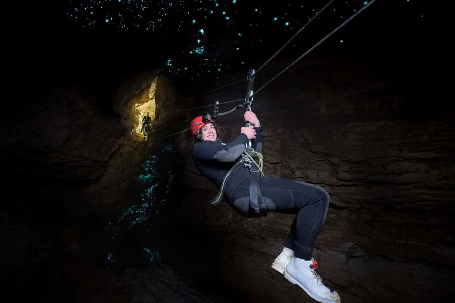 Waitomo Caves Black Abyss Ultimate Caving Experience - Ruakuri Cave in the dark: moving through black water
